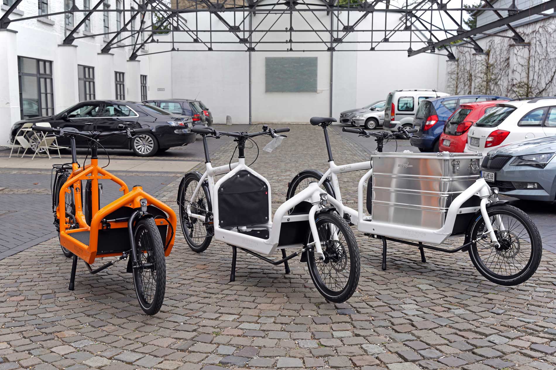 Unterschiedliche Lastenräder: BULLITT Clockwork (orange) und BULLITT Milk plus (weiß) mit und ohne Transportbox